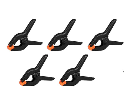 Five black clamps with orange tips 
